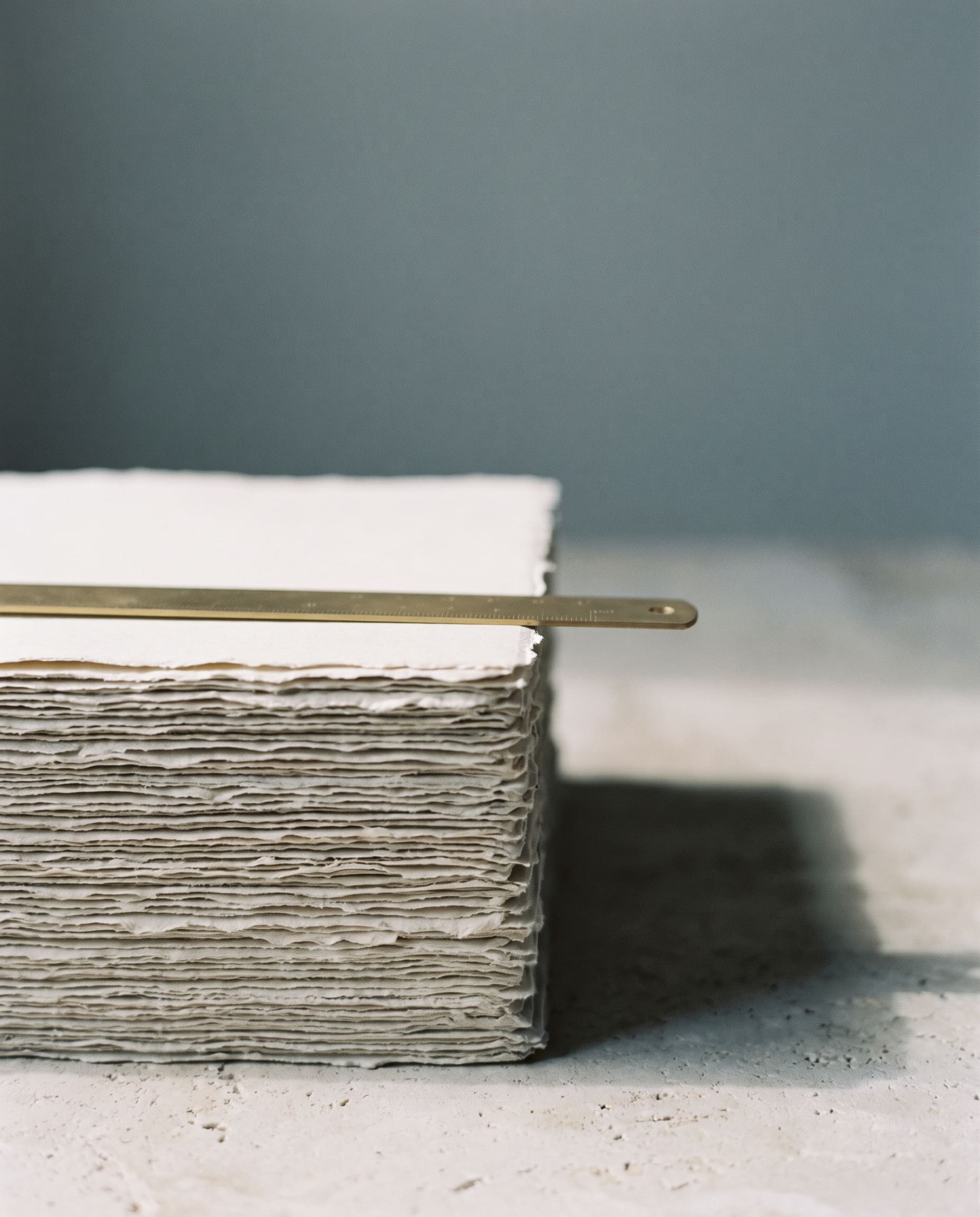 Stacked paper and a brass edge in soft light